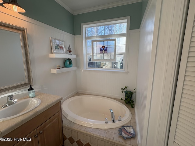 bathroom featuring ornamental molding, tiled bath, and vanity