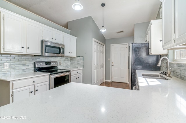 kitchen featuring pendant lighting, white cabinets, and appliances with stainless steel finishes