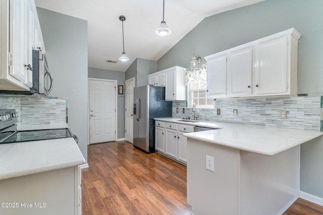 kitchen with white cabinetry, kitchen peninsula, pendant lighting, lofted ceiling, and appliances with stainless steel finishes