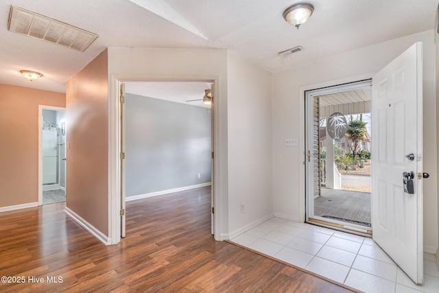 foyer entrance featuring hardwood / wood-style floors, ceiling fan, and a textured ceiling