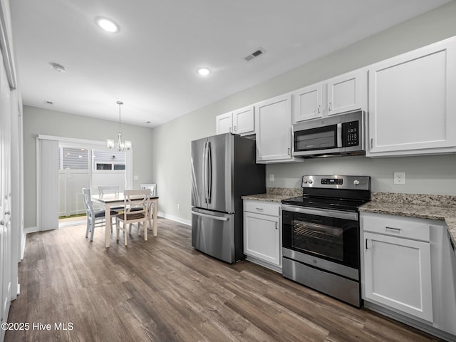 kitchen featuring hanging light fixtures, dark wood-type flooring, white cabinets, and appliances with stainless steel finishes