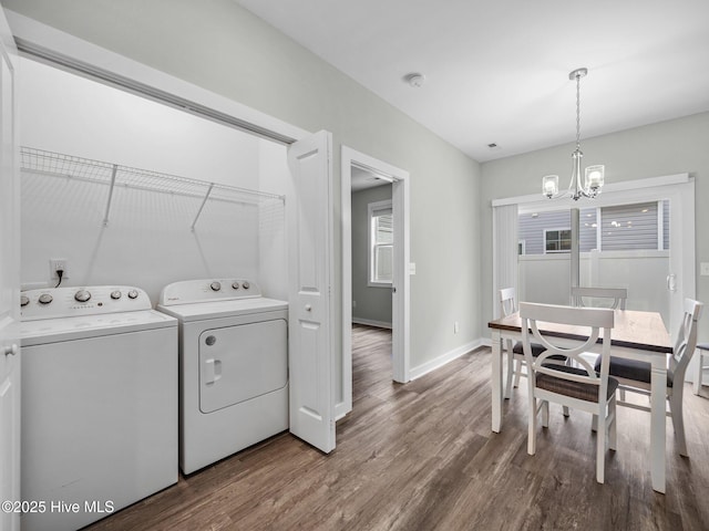 laundry area featuring wood-type flooring, a chandelier, and washing machine and dryer