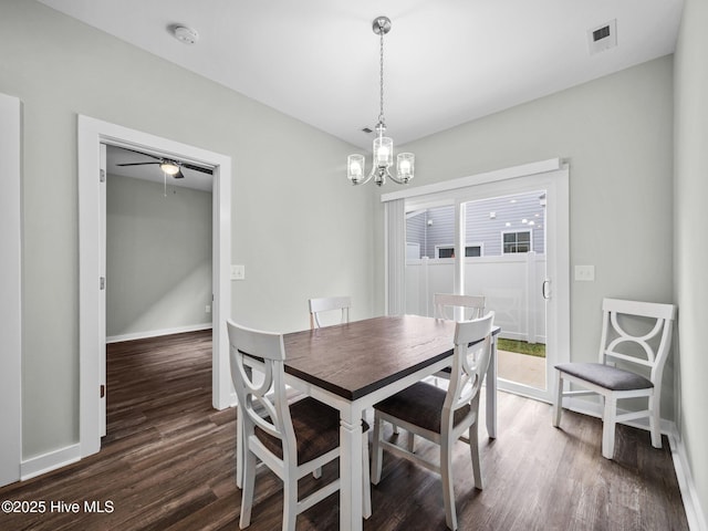 dining space featuring ceiling fan with notable chandelier and dark hardwood / wood-style floors