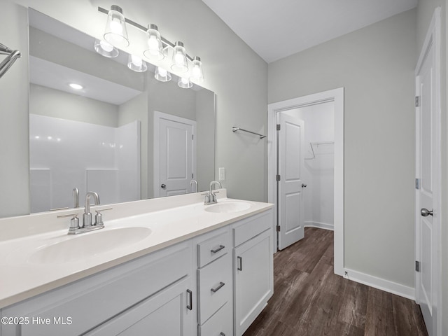 bathroom featuring wood-type flooring, vanity, and a shower