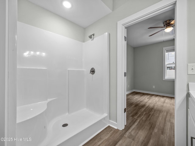 bathroom with a shower, wood-type flooring, vanity, and ceiling fan