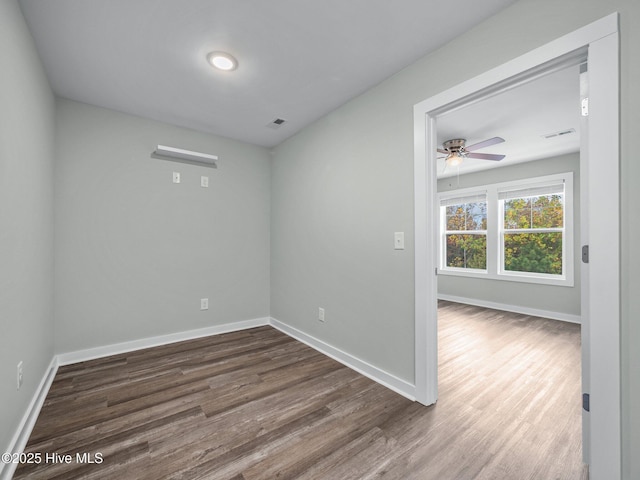 unfurnished room with ceiling fan and dark hardwood / wood-style floors