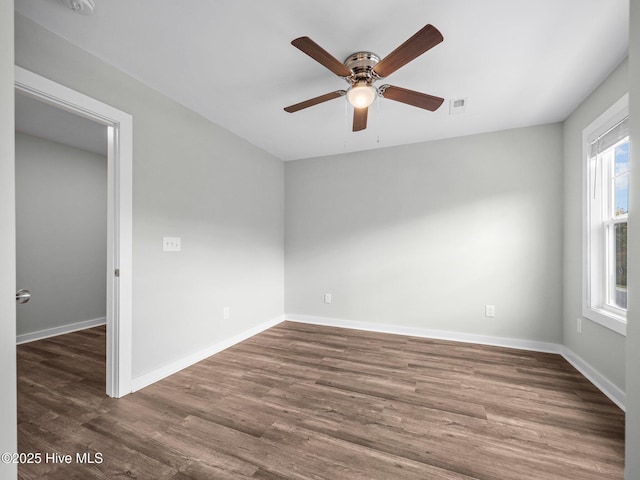 empty room with dark hardwood / wood-style floors and ceiling fan