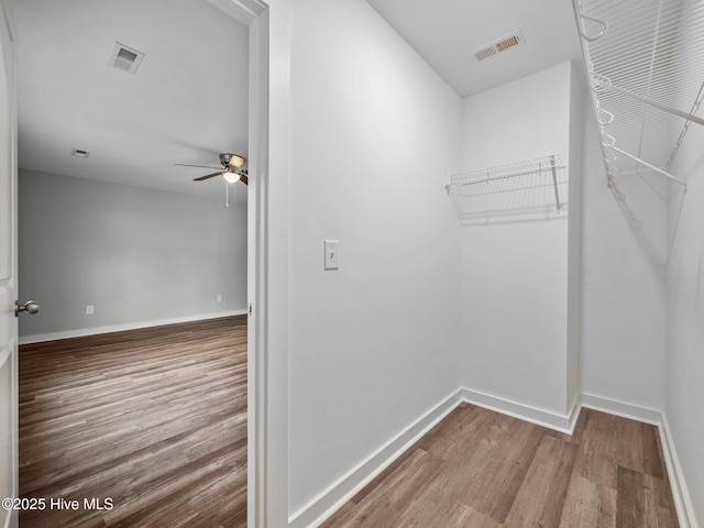 walk in closet with hardwood / wood-style floors and ceiling fan