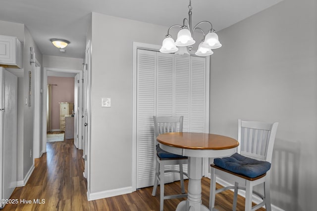 dining space with a chandelier and dark hardwood / wood-style flooring