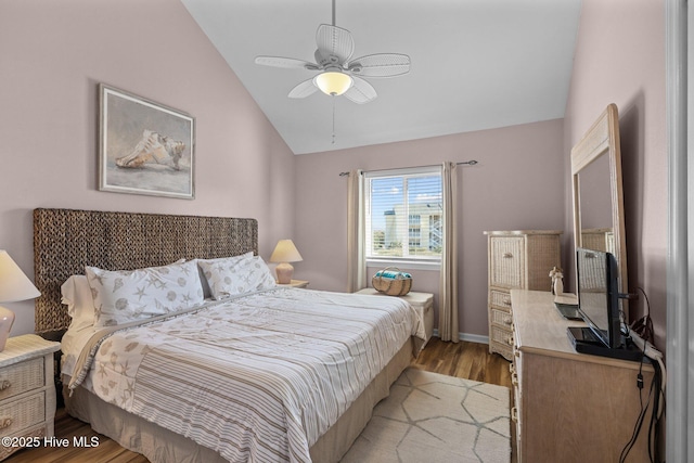 bedroom featuring light wood-type flooring, vaulted ceiling, and ceiling fan