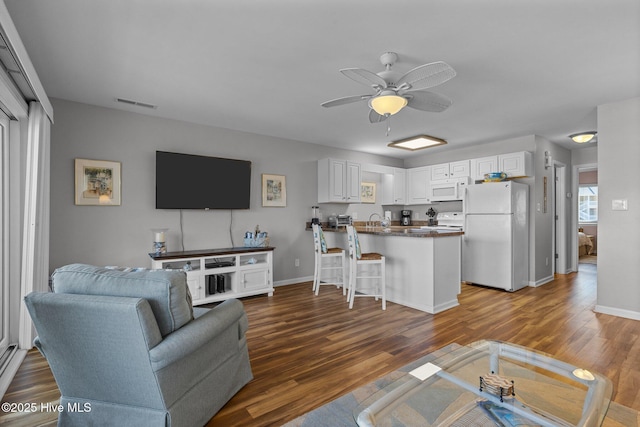 living room featuring dark hardwood / wood-style floors, ceiling fan, and sink