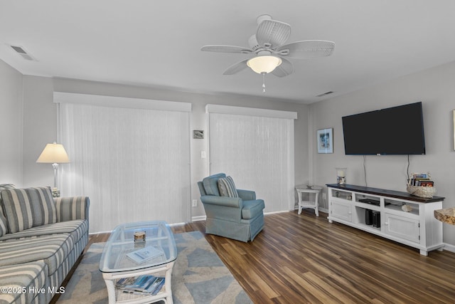 living room with ceiling fan and dark wood-type flooring