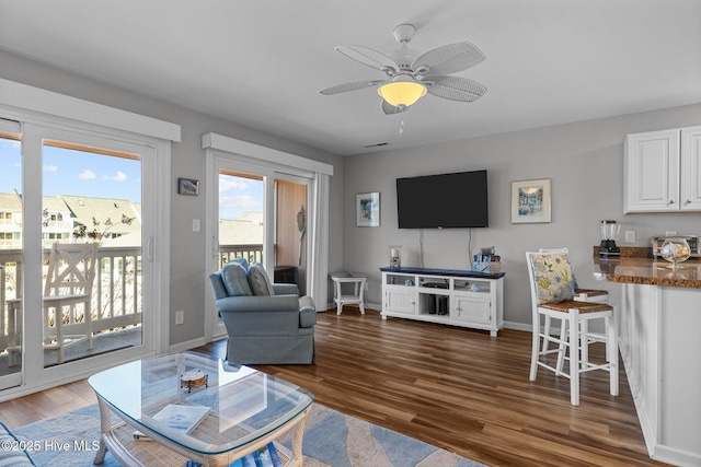 living room featuring ceiling fan and dark hardwood / wood-style flooring