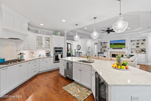 kitchen featuring dishwasher, sink, wine cooler, pendant lighting, and white cabinets