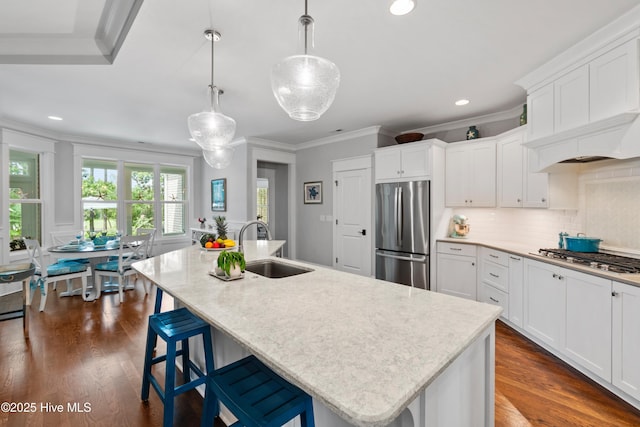 kitchen featuring pendant lighting, a kitchen island with sink, and appliances with stainless steel finishes