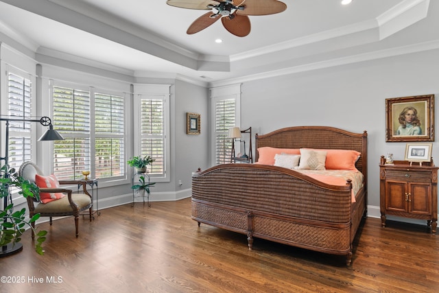 bedroom featuring ceiling fan, dark wood-type flooring, and a tray ceiling