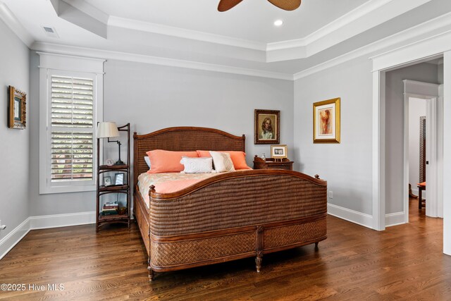 bedroom featuring a raised ceiling, crown molding, ceiling fan, and wood-type flooring