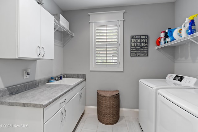 laundry room featuring cabinets, light tile patterned floors, washer and dryer, and sink