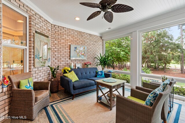 living room featuring ceiling fan, ornamental molding, brick wall, and light hardwood / wood-style flooring