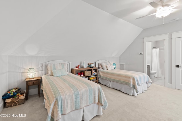 bedroom with ceiling fan, light colored carpet, connected bathroom, and vaulted ceiling