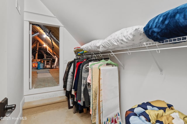 walk in closet featuring carpet floors and lofted ceiling