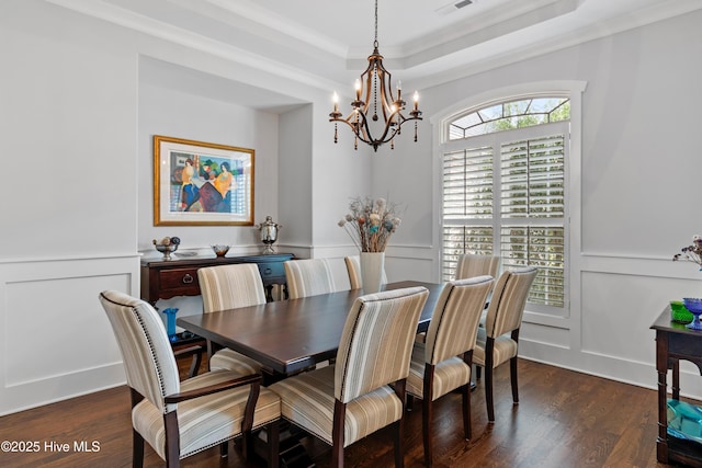 dining room featuring crown molding, dark hardwood / wood-style flooring, a healthy amount of sunlight, and a notable chandelier