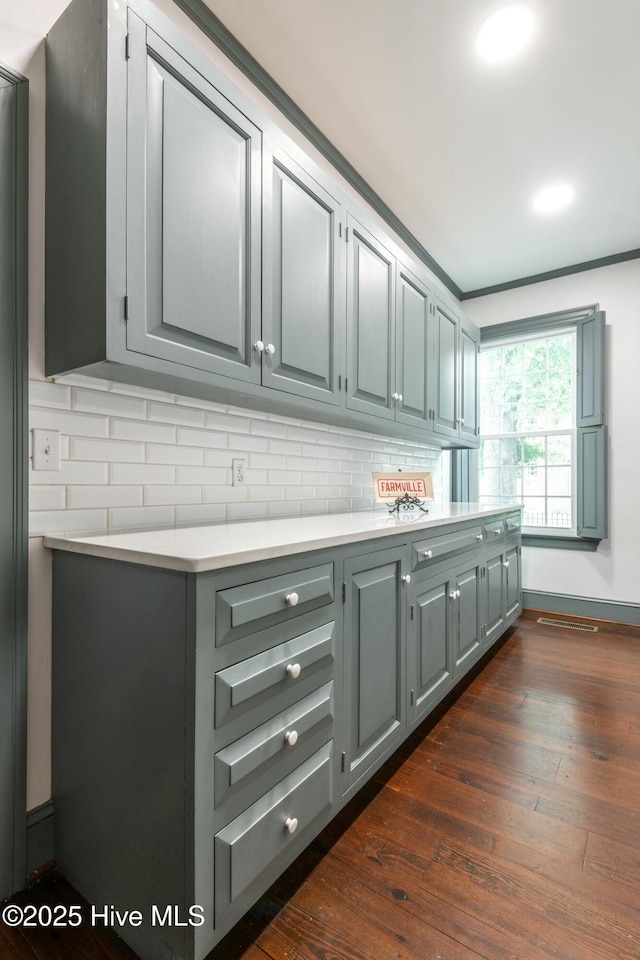 kitchen with dark wood-type flooring, decorative backsplash, and gray cabinetry