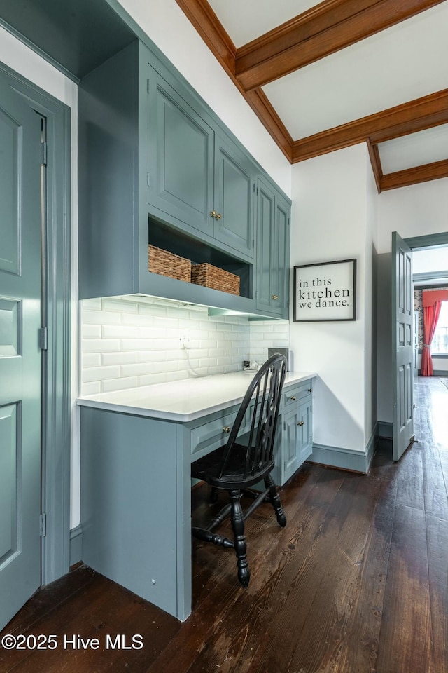 office area with dark hardwood / wood-style flooring, beam ceiling, built in desk, and crown molding