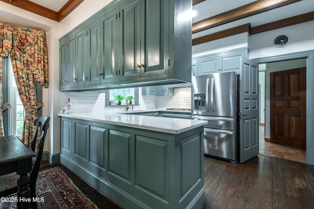 kitchen with kitchen peninsula, tasteful backsplash, green cabinetry, stainless steel appliances, and crown molding