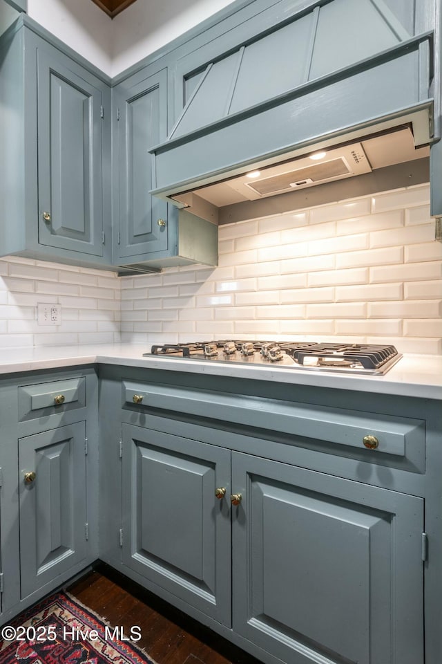 kitchen with tasteful backsplash, stainless steel gas stovetop, dark hardwood / wood-style floors, and wall chimney range hood