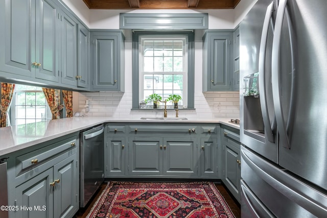 kitchen featuring sink, backsplash, gray cabinets, and stainless steel appliances