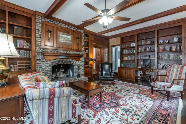 living room with ceiling fan, built in features, beam ceiling, and a fireplace