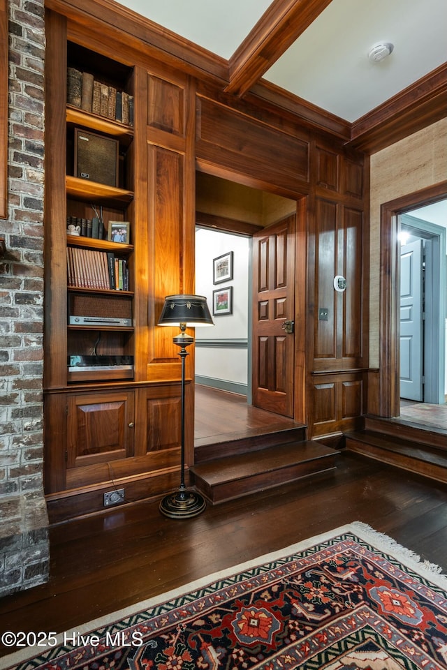 interior space featuring hardwood / wood-style flooring, wood walls, crown molding, and beamed ceiling