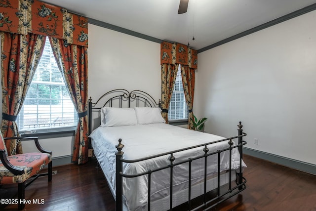 bedroom featuring dark wood-type flooring, ornamental molding, and ceiling fan