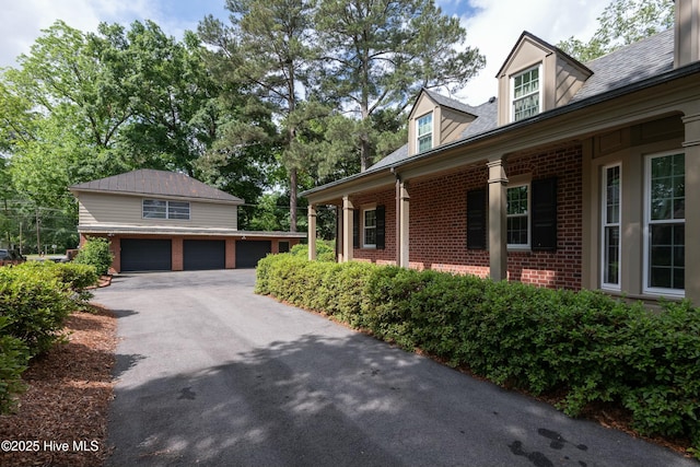 view of property exterior featuring a garage and an outbuilding