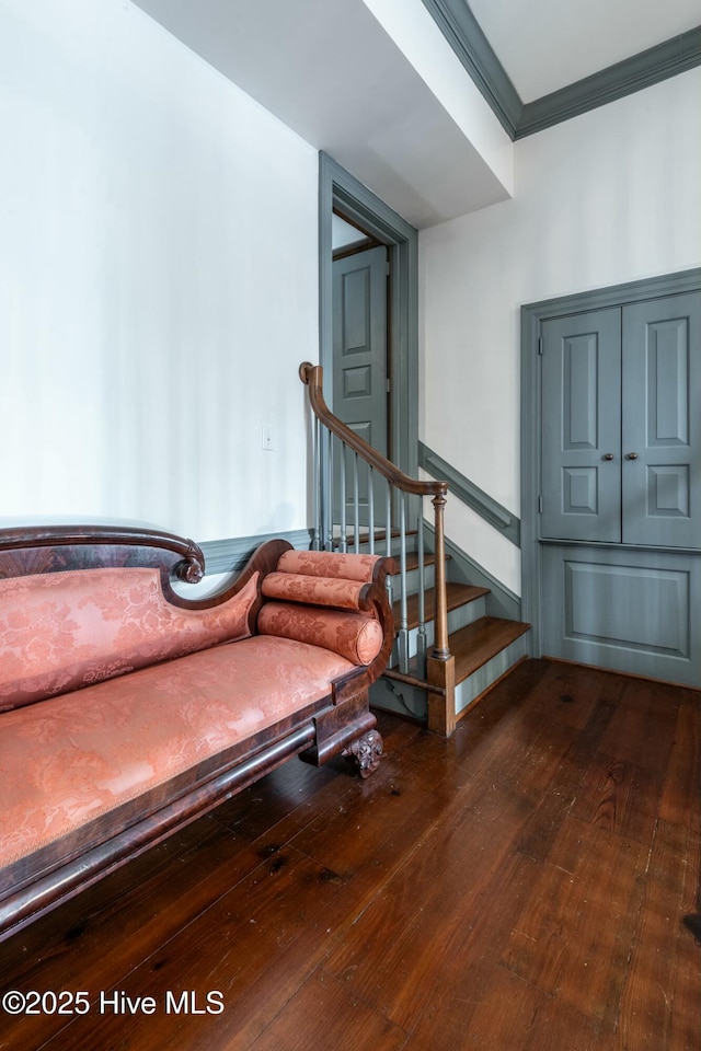 staircase featuring crown molding and wood-type flooring