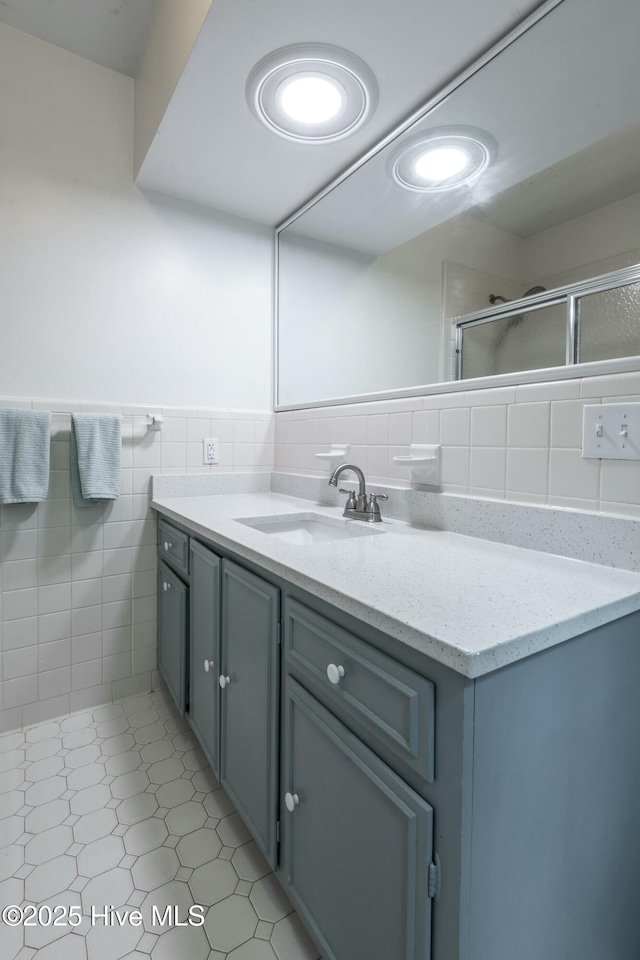 bathroom with vanity, tile walls, and walk in shower