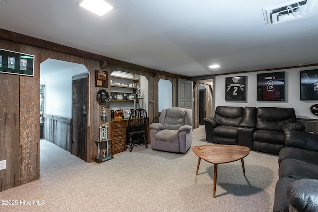 carpeted living room with wooden walls