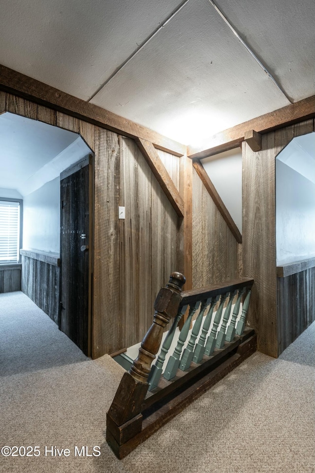 interior space featuring carpet flooring and wooden walls