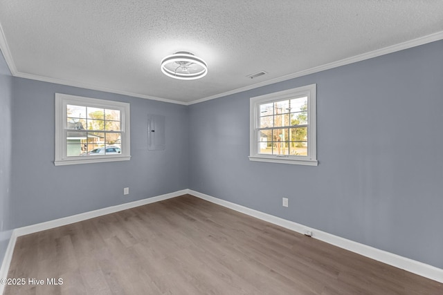 unfurnished room with hardwood / wood-style flooring, ornamental molding, and a textured ceiling