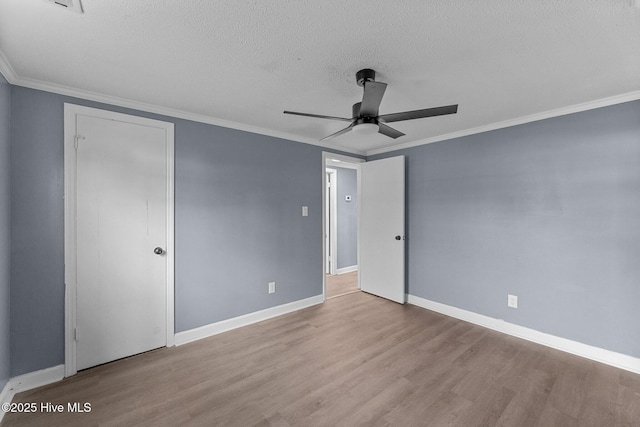 unfurnished room featuring crown molding, ceiling fan, light hardwood / wood-style floors, and a textured ceiling