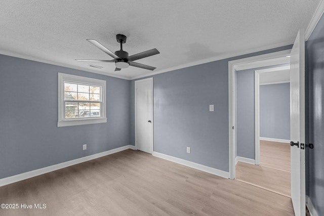 unfurnished bedroom with ornamental molding, ceiling fan, light hardwood / wood-style floors, a textured ceiling, and a closet