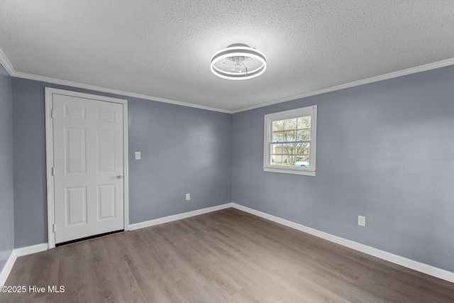 spare room featuring crown molding, light hardwood / wood-style flooring, and a textured ceiling