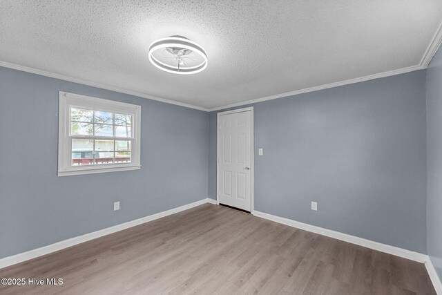 empty room with crown molding, a textured ceiling, and light hardwood / wood-style flooring