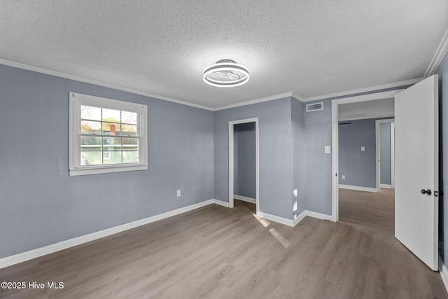 unfurnished bedroom with crown molding, a closet, hardwood / wood-style floors, and a textured ceiling