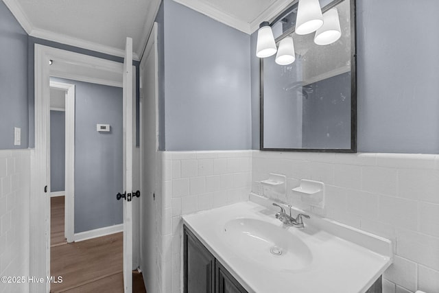 bathroom featuring vanity, hardwood / wood-style floors, ornamental molding, and tile walls