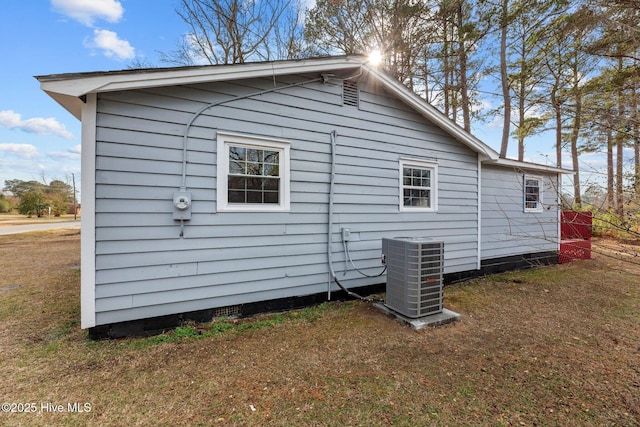 view of side of property with a lawn and central air condition unit