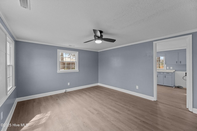 empty room with crown molding, ceiling fan, a textured ceiling, and light hardwood / wood-style floors