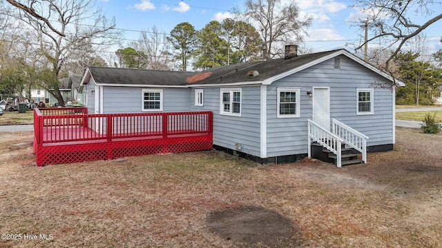 rear view of property with a deck and a lawn