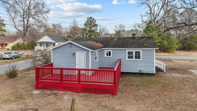 rear view of property featuring a yard and a deck